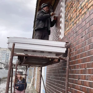 Workers mounting Royal Facade panels during winter construction season